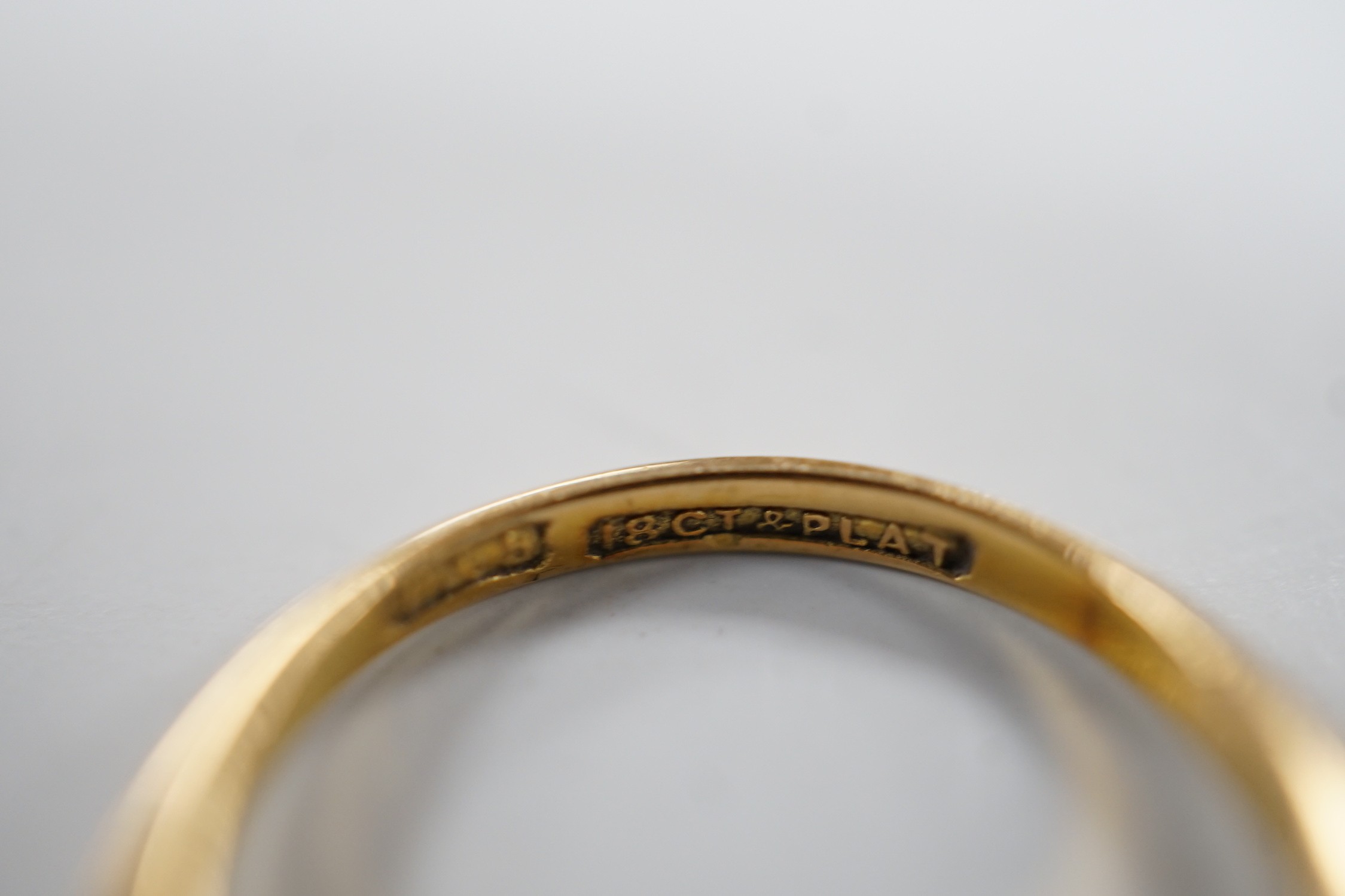 An 18ct, plat and graduated five stone diamond set half hoop ring, size J/K, gross weight 3.3 grams.